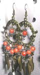 Victorian circular fish hook earring with orange beads holding wavy shape bronze strip design