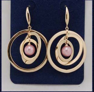 Designer wholesale pearl jewelry store distributing whole fashions. Simulated gold plated hoops circulating around a pink imitation pearl..