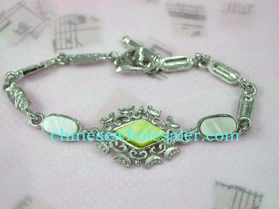 Online silver plated wholesale fashion jewelry. Pale light green seashell embedded loosely connected long strip forming fashion bracelet, toggle clasp for closure.    
              
        