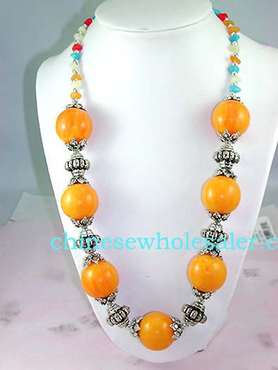 High quality fashion wholesale jewelry supplied by online wholesaler. Large, dark yellow beaded necklace with silver plated chain connecting each bead and changing to small blue, orange, red, and whote beads around neck..    
              
        