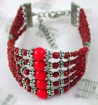 China wholesale colored beaded jewelry gifts supplied online. Fashion bracelet with five small red beaded strings each holding decorated silver beads and a large red bead in center.