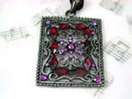 Wholesale crystal fashion import distributors supply Picture frame shape pendant with purple cz flower design at center surrounded by red cz stones atop vine decor and has four purple cz gems in each corner.