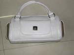 China manufactured fashion purses and handbag supplied by online wholesaler. White imitation leather handbag has double handles attached by meatal hoop, side pockets for cell phones or keys, and added front pocket.