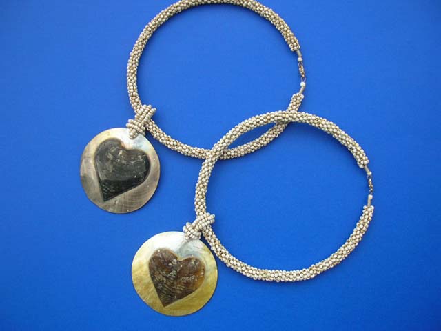 Love designed, heart shape in center of round pendant hanging from twisted bead necklace - bali gift exchange