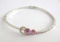 Fashion bangle with multi mini pink cz on one side holding two rounded pink cz stone in middle