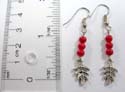 Fashion earring with 3 rounded red faux stone and silver maple leaf dangle hanging on bottom, fish hook back
