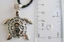 Fashion necklace with black twisted cord string holding a turtle mental pendant at center
